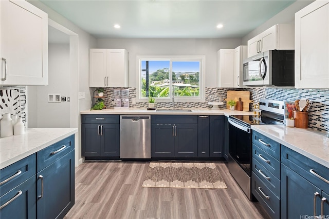 45-563 Kukane St, Kaneohe, HI 96744 - kitchen with stainless steel appliances, white cabinetry, backsplash, and recessed lighting
