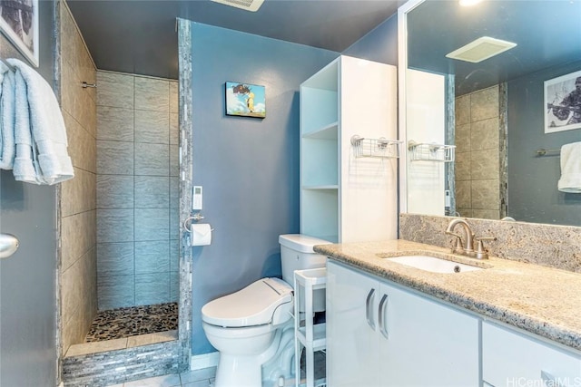 full bath featuring toilet, vanity, and a tile shower