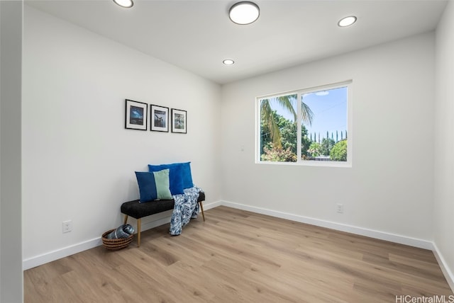 sitting room featuring baseboards, recessed lighting, and light wood finished floors