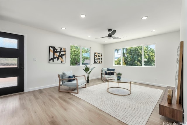 sitting room featuring baseboards, light wood-type flooring, and recessed lighting