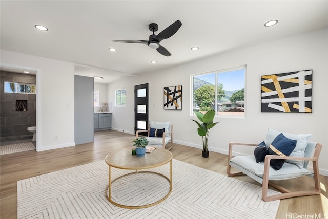 living area featuring baseboards, ceiling fan, recessed lighting, and light wood finished floors