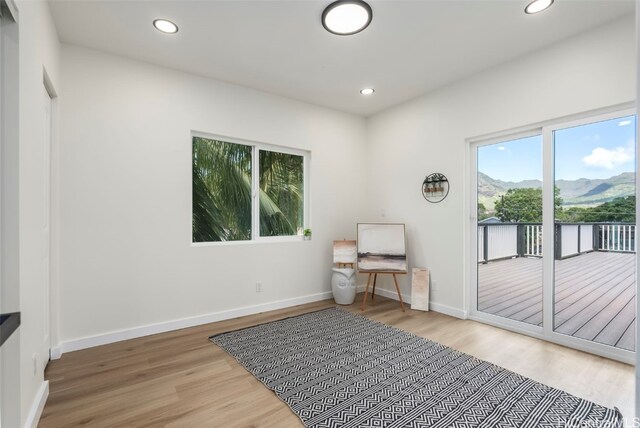 living area with baseboards, wood finished floors, and recessed lighting