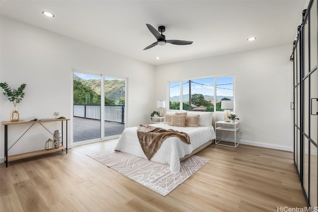 bedroom featuring multiple windows, access to exterior, light wood-style flooring, and recessed lighting