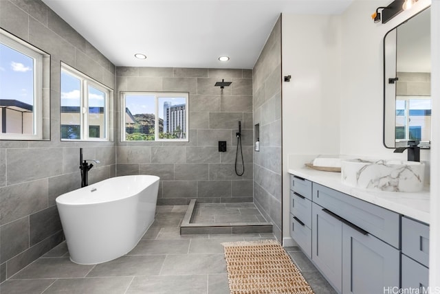 full bathroom featuring tile patterned floors, tiled shower, vanity, a soaking tub, and recessed lighting