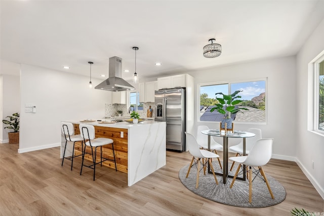 84-1001 Lahaina St Unit 1, Waianae, HI 96792 - kitchen with stainless steel fridge with ice dispenser, white cabinetry, a center island, island exhaust hood, and decorative backsplash