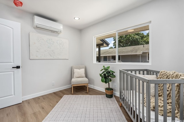 84-1001 Lahaina St Unit 1, Waianae, HI 96792 - bedroom with recessed lighting, wood finished floors, an AC wall unit, a crib, and baseboards