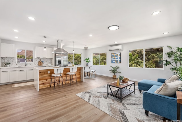 84-1001 Lahaina St Unit 1, Waianae, HI 96792 - living room featuring light wood-type flooring, a wall mounted AC, baseboards, and recessed lighting