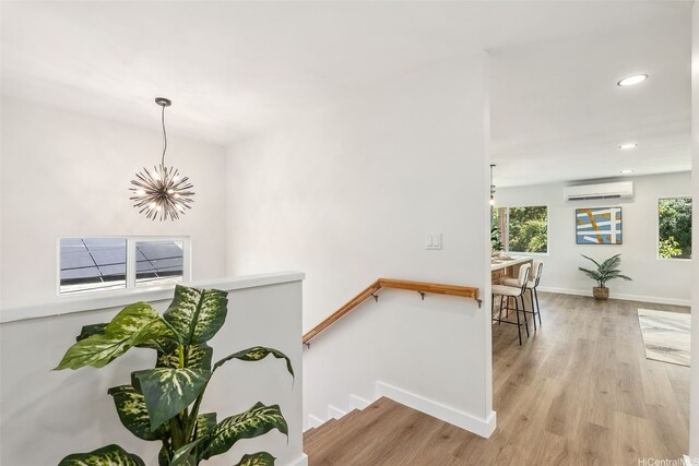 84-1001 Lahaina St Unit 1, Waianae, HI 96792 - stairway featuring baseboards, a notable chandelier, recessed lighting, wood finished floors, and a wall unit AC