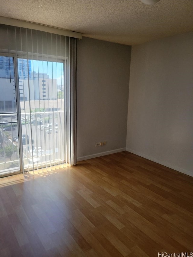 731 Amana St Unit 704, Honolulu, HI 96814 - unfurnished room with wood finished floors, a textured ceiling, and baseboards