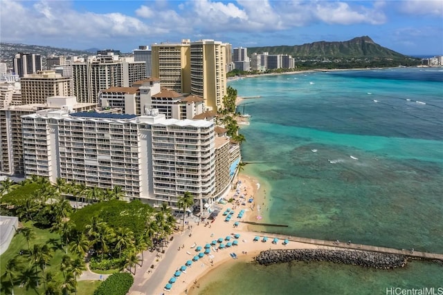 drone / aerial view with a water view, a view of the beach, and a view of city