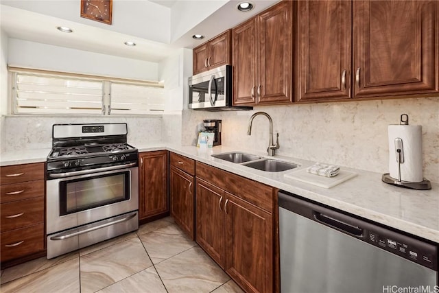 kitchen featuring a sink, light countertops, appliances with stainless steel finishes, and tasteful backsplash