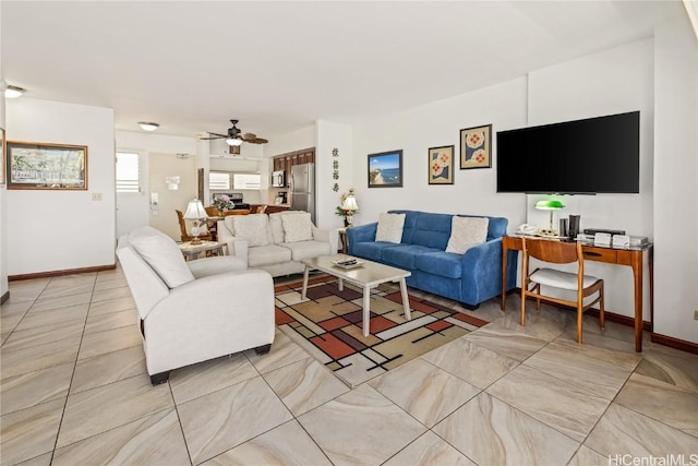 living room with baseboards and a ceiling fan