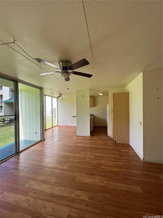 95-017 Kuahelani Ave Unit 124, Mililani, HI 96789 - unfurnished room featuring a textured ceiling, wood finished floors, a ceiling fan, and concrete block wall