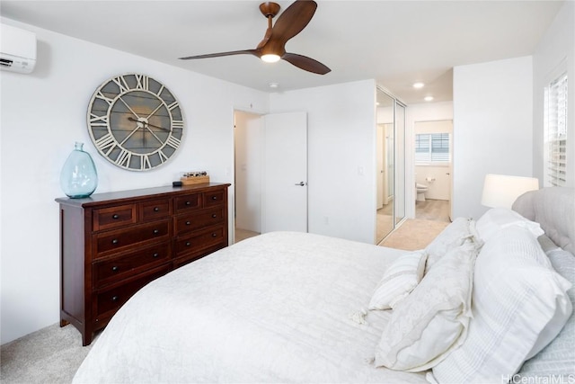 bedroom featuring a wall mounted AC, ensuite bathroom, light colored carpet, ceiling fan, and recessed lighting