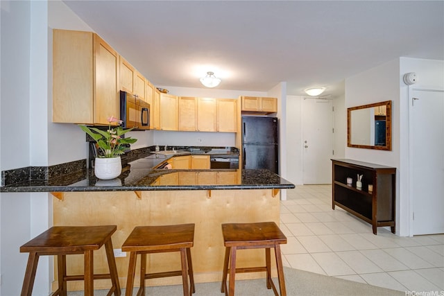 430 Kaiolu St Unit 607, Honolulu, HI 96815 - kitchen featuring black appliances, light brown cabinetry, a peninsula, a sink, and dark stone counters