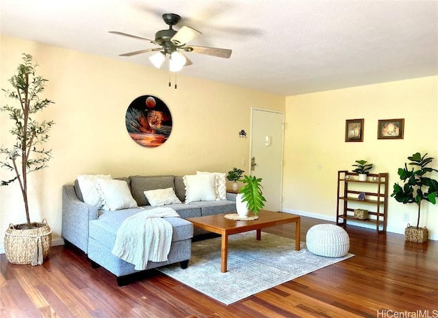 living room featuring a ceiling fan, baseboards, and wood finished floors