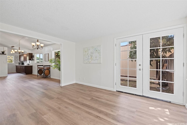 92-1158 Makamai Loop, Kapolei, HI 96707 - unfurnished living room featuring a chandelier, light wood finished floors, french doors, and a textured ceiling