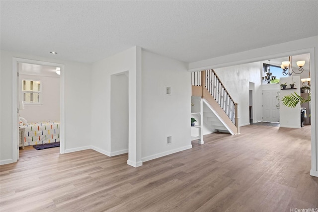 92-1158 Makamai Loop, Kapolei, HI 96707 - unfurnished living room featuring a chandelier, light wood finished floors, stairs, and a textured ceiling