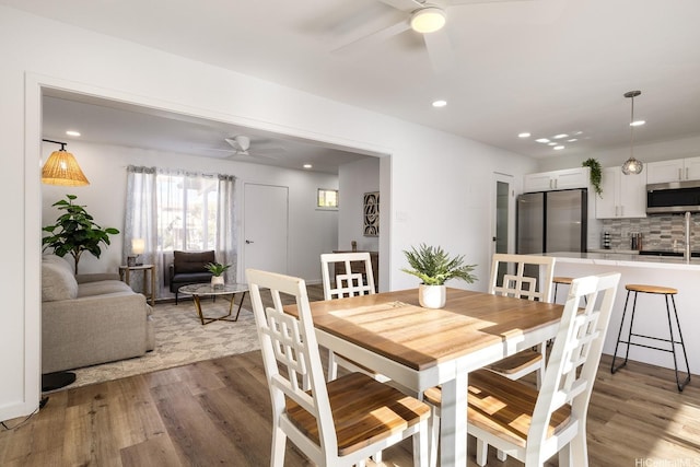 dining space with recessed lighting, a ceiling fan, and light wood-style flooring