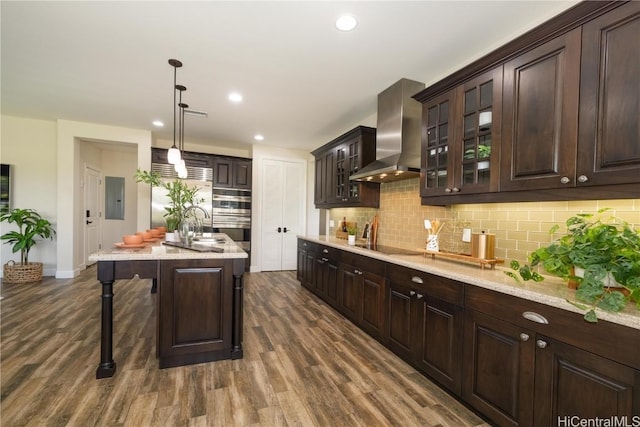 91-1072 Waikapoo St, Ewa Beach, HI 96706 - kitchen with electric panel, wall chimney exhaust hood, dark brown cabinets, tasteful backsplash, and a kitchen breakfast bar