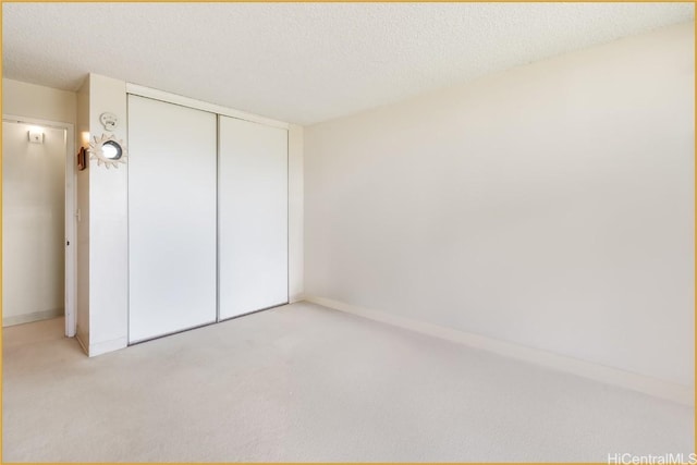 1830 Wilikina Dr Unit 612, Wahiawa, HI 96786 - unfurnished bedroom featuring baseboards, a closet, light colored carpet, and a textured ceiling