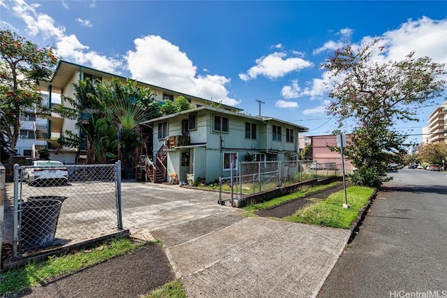 view of front facade with fence and concrete driveway
