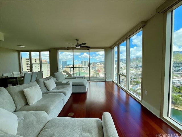 sunroom with baseboards, wood finished floors, a view of city, and a wall of windows
