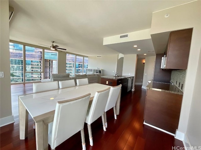 dining space featuring visible vents, a wall of windows, baseboards, a ceiling fan, and dark wood-type flooring
