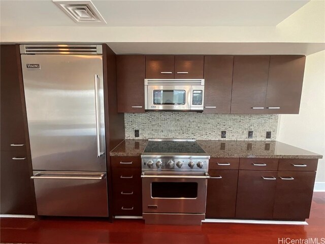 kitchen with decorative backsplash, modern cabinets, premium appliances, and visible vents