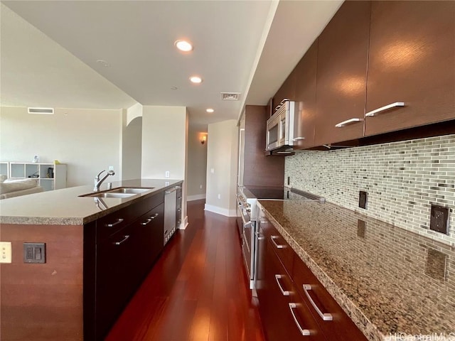 kitchen featuring decorative backsplash, visible vents, modern cabinets, appliances with stainless steel finishes, and a sink