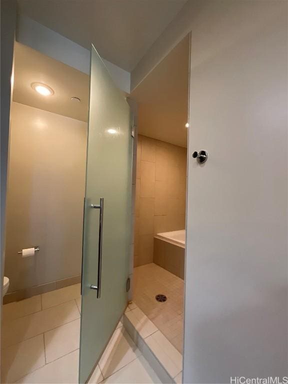 bathroom featuring baseboards, toilet, tile patterned floors, and a shower stall