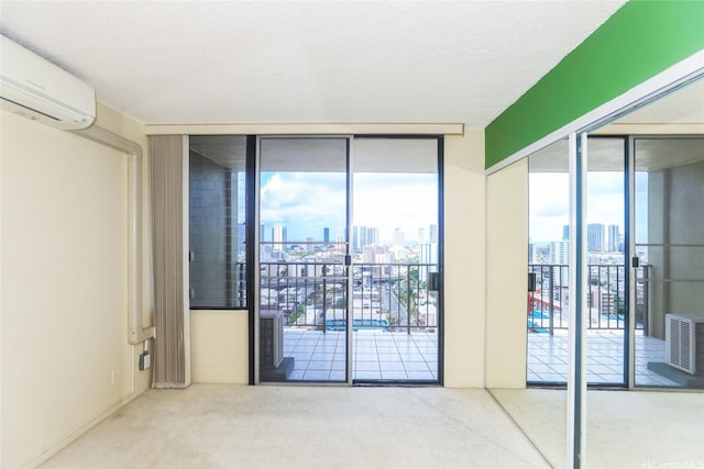 carpeted empty room with a skyline view, a wall mounted air conditioner, plenty of natural light, and floor to ceiling windows