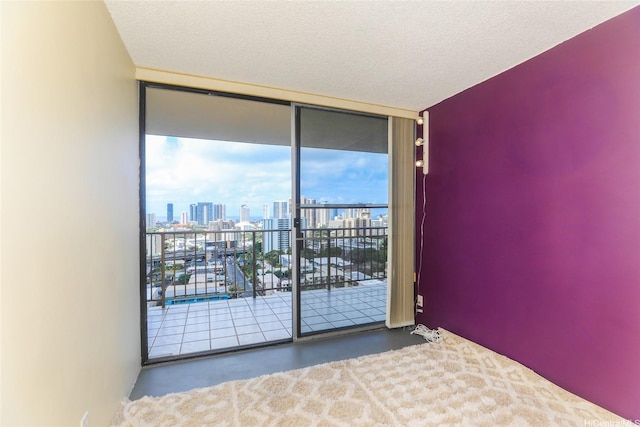 unfurnished bedroom featuring expansive windows, access to exterior, and a view of skyline