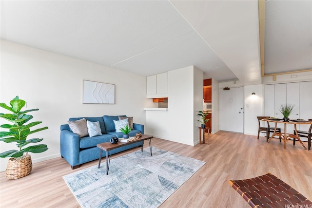 living room with baseboards and light wood-style flooring