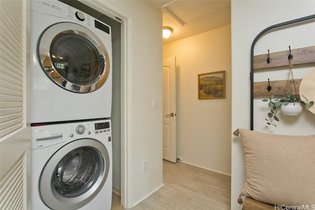 laundry room with stacked washer / dryer, light wood-type flooring, and laundry area