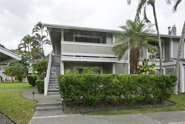 view of front of house with stairway and a front lawn