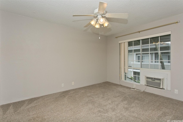 spare room with carpet, a textured ceiling, a wall unit AC, and ceiling fan