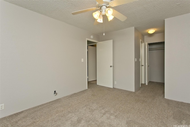 unfurnished bedroom featuring a textured ceiling, a closet, carpet flooring, and a ceiling fan