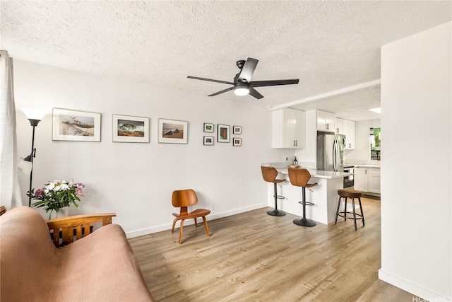 68-037 Apuhihi St Unit B, Waialua, HI 96791 - sitting room with ceiling fan, light wood-style flooring, a textured ceiling, and baseboards