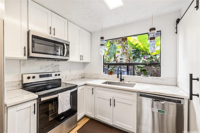 68-037 Apuhihi St Unit B, Waialua, HI 96791 - kitchen with appliances with stainless steel finishes, a sink, white cabinets, light stone countertops, and a textured ceiling