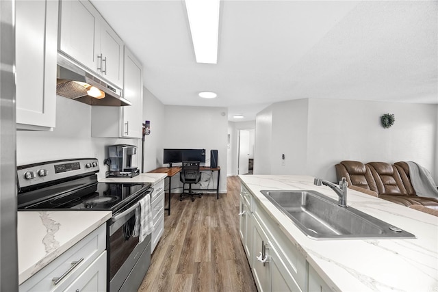 kitchen featuring open floor plan, stainless steel electric range, a sink, and under cabinet range hood