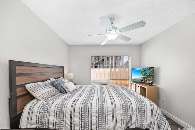 bedroom with baseboards, a ceiling fan, wood finished floors, and a textured ceiling