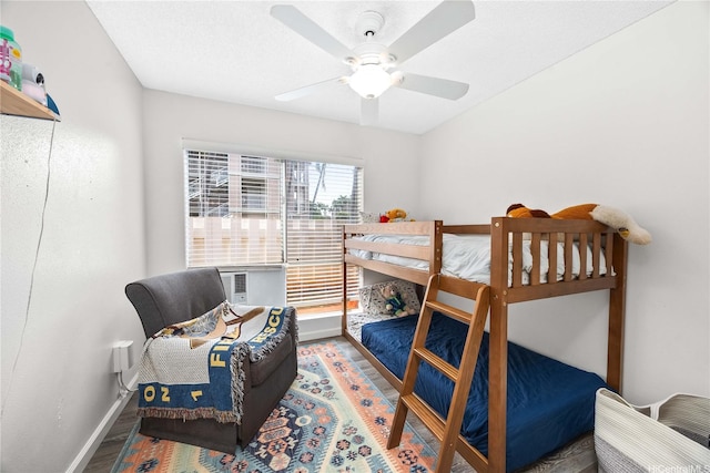 bedroom with cooling unit, wood finished floors, ceiling fan, and baseboards