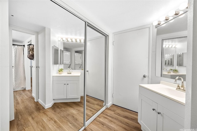 full bathroom with wood finished floors, two vanities, a sink, and a shower with curtain