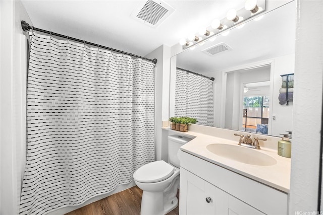 bathroom featuring vanity, visible vents, toilet, and wood finished floors
