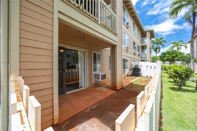 view of patio with cooling unit and a balcony