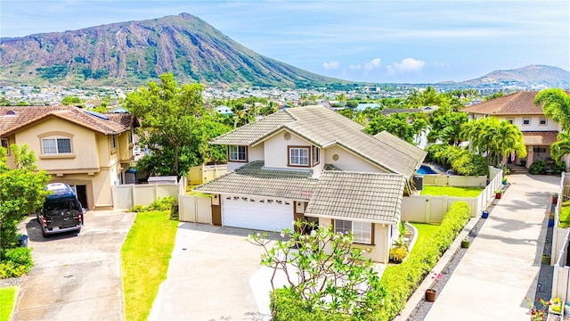 1000 Kaolo St, Honolulu, HI 96825 - exterior space featuring an attached garage, a mountain view, concrete driveway, stucco siding, and a tiled roof