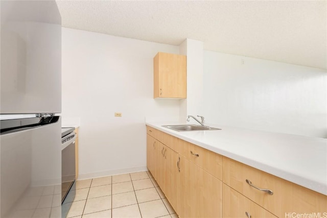 kitchen featuring light brown cabinets, light countertops, a sink, and light tile patterned flooring