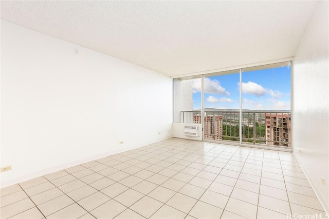 unfurnished room with light tile patterned floors, expansive windows, and a textured ceiling