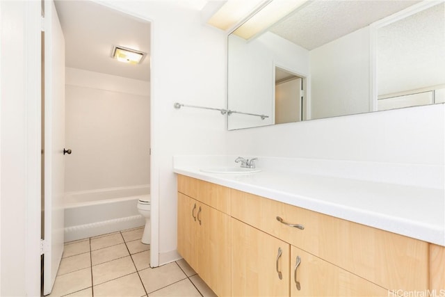 bathroom with toilet, vanity, and tile patterned floors